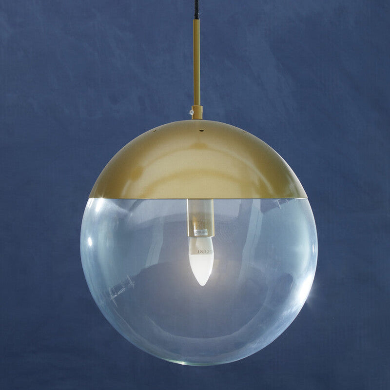 Spherical pendant light with gold top and clear glass on a blue background