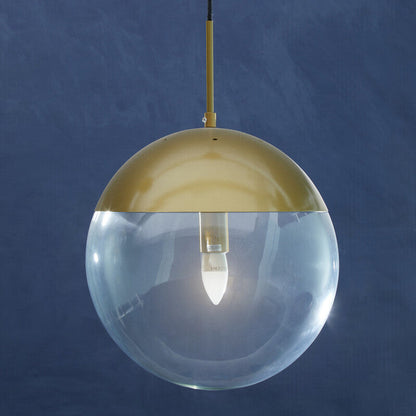Spherical pendant light with gold top and clear glass on a blue background