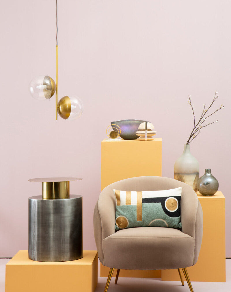 Modern interior design with a chair, lamp, and decorative items against a pink wall.