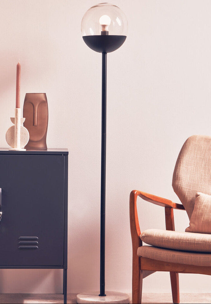 Modern interior with a tall floor lamp, side cabinet, and armchair.