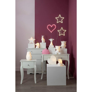 Neon lights shaped like stars and a heart on a table against a purple wall.