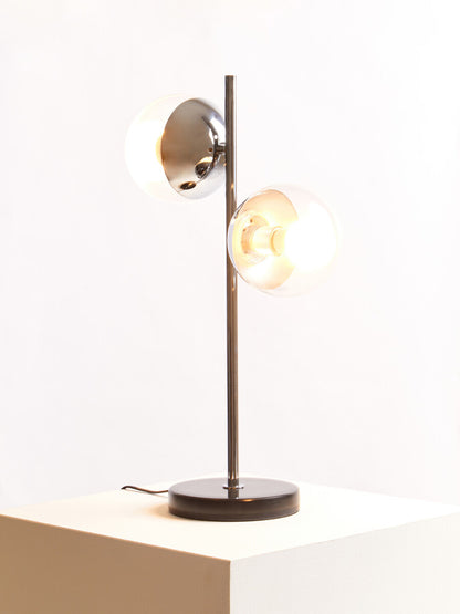 Modern table lamp with two light bulbs on a white surface