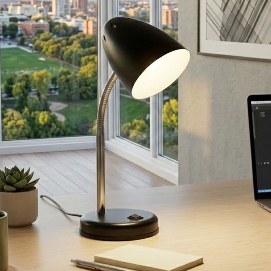 Black desk lamp on a desk with a laptop and window view