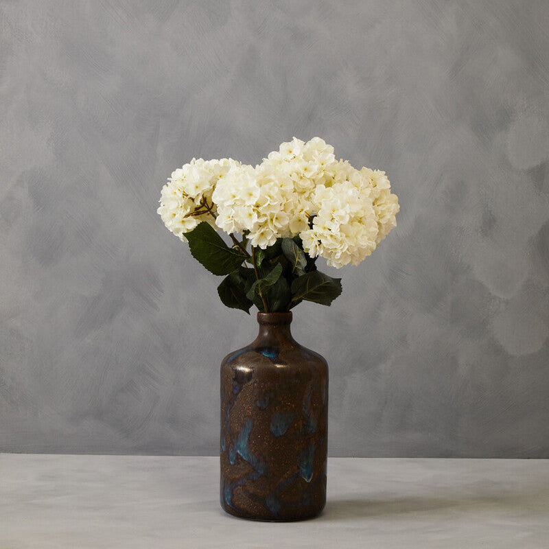 Decorative vase with white flowers against a gray background