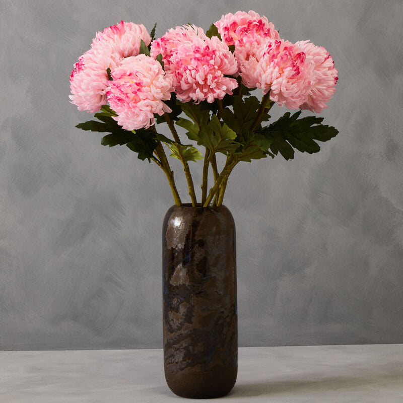 Pink flowers in a dark vase against a gray background