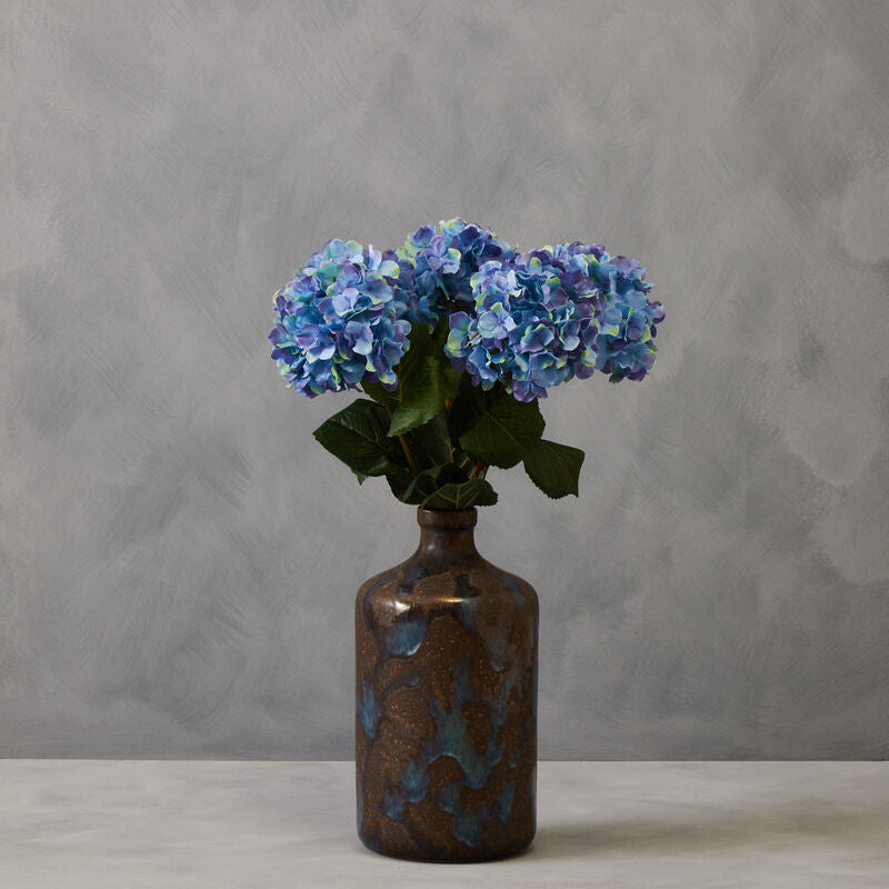 Decorative vase with blue flowers against a gray background