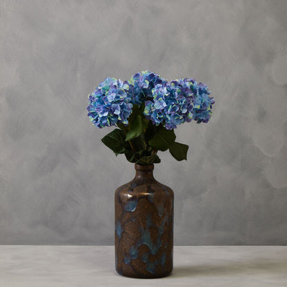Decorative vase with blue flowers against a gray background