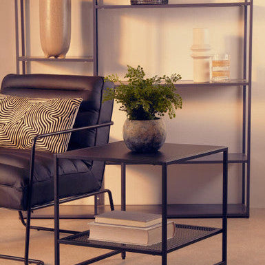 Modern living room with a black chair, table, and decorative items.