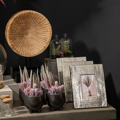 Decorative items including a woven hat, framed pictures, and plants on a dark background