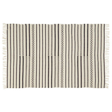 Striped rug with black and beige pattern on a white background