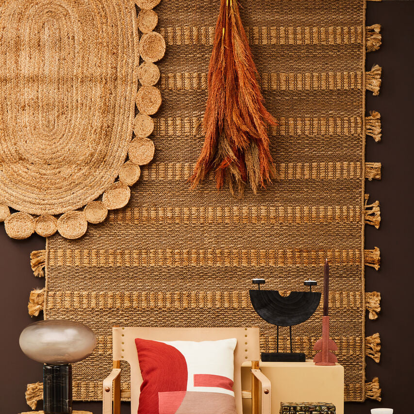 Decorative room setting with a chair, pillows, and various decor items against a textured wall.