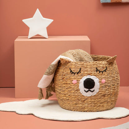 Woven basket with animal face design on a pink surface with star decoration