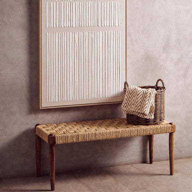 Woven bench with basket and abstract art on a neutral wall