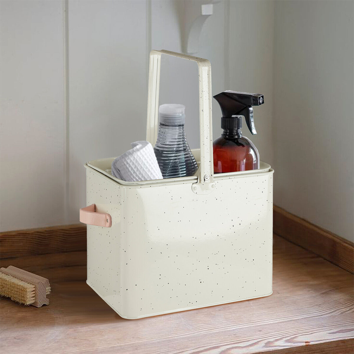 Beige storage basket with cleaning supplies on a wooden floor