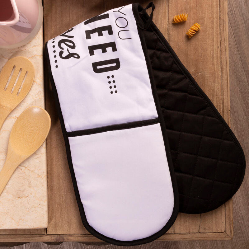 Black and white oven mitt with text on a wooden surface with pasta and jars.