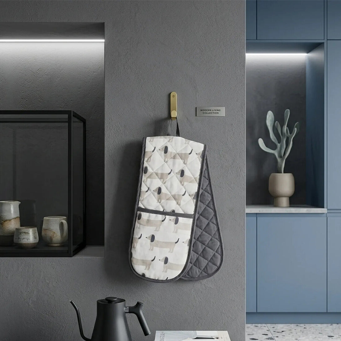 Quilted oven mitt with geometric pattern hanging on a wall in a kitchen setting.