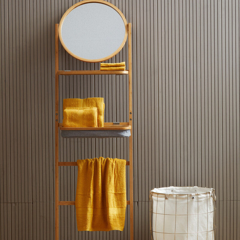 Towel rack with round mirror and yellow towels against a striped wall.