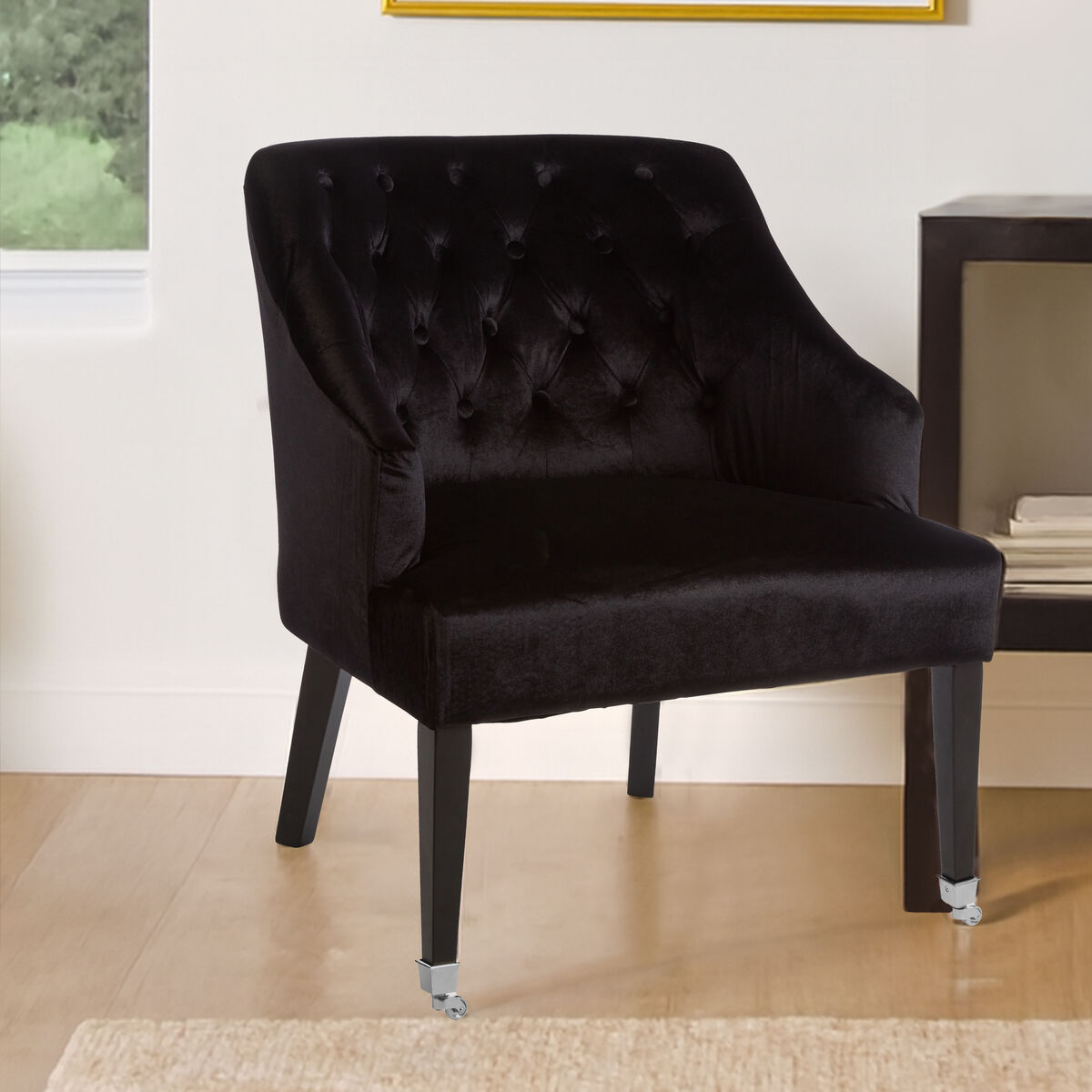 Black upholstered chair in a room with a window and table.