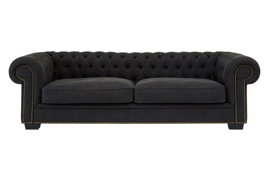 Dark gray tufted sofa on a white background