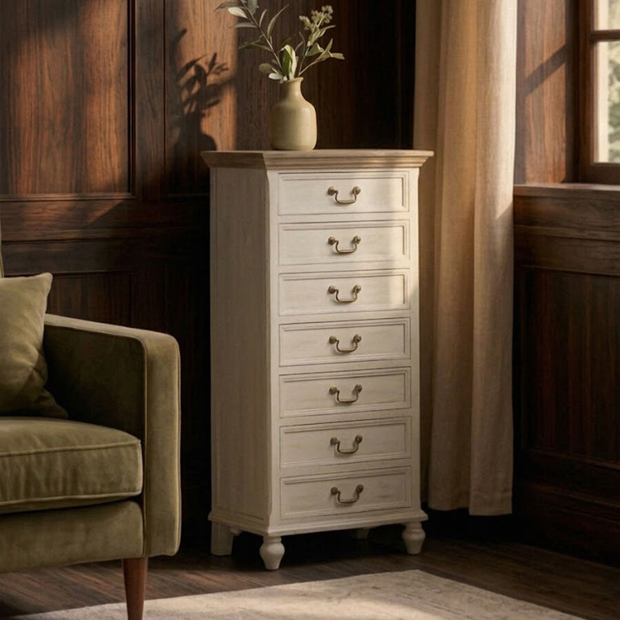 White dresser with drawers next to a green armchair in a room with wooden walls and a window.