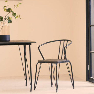 Black metal chair and table against a beige wall