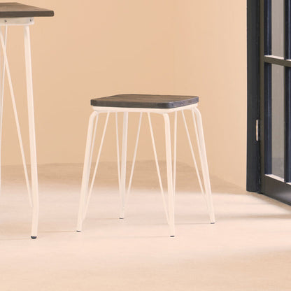 Stool with a black seat and white metal legs in a minimalistic room.
