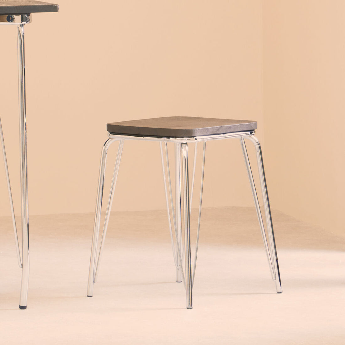 Stool with wooden seat and metal legs on a beige background