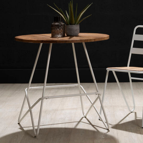 Small round table with a wooden top and metal legs, accompanied by a striped chair on a dark background.