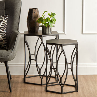 Modern living room with a gray armchair, decorative tables, and a plant.