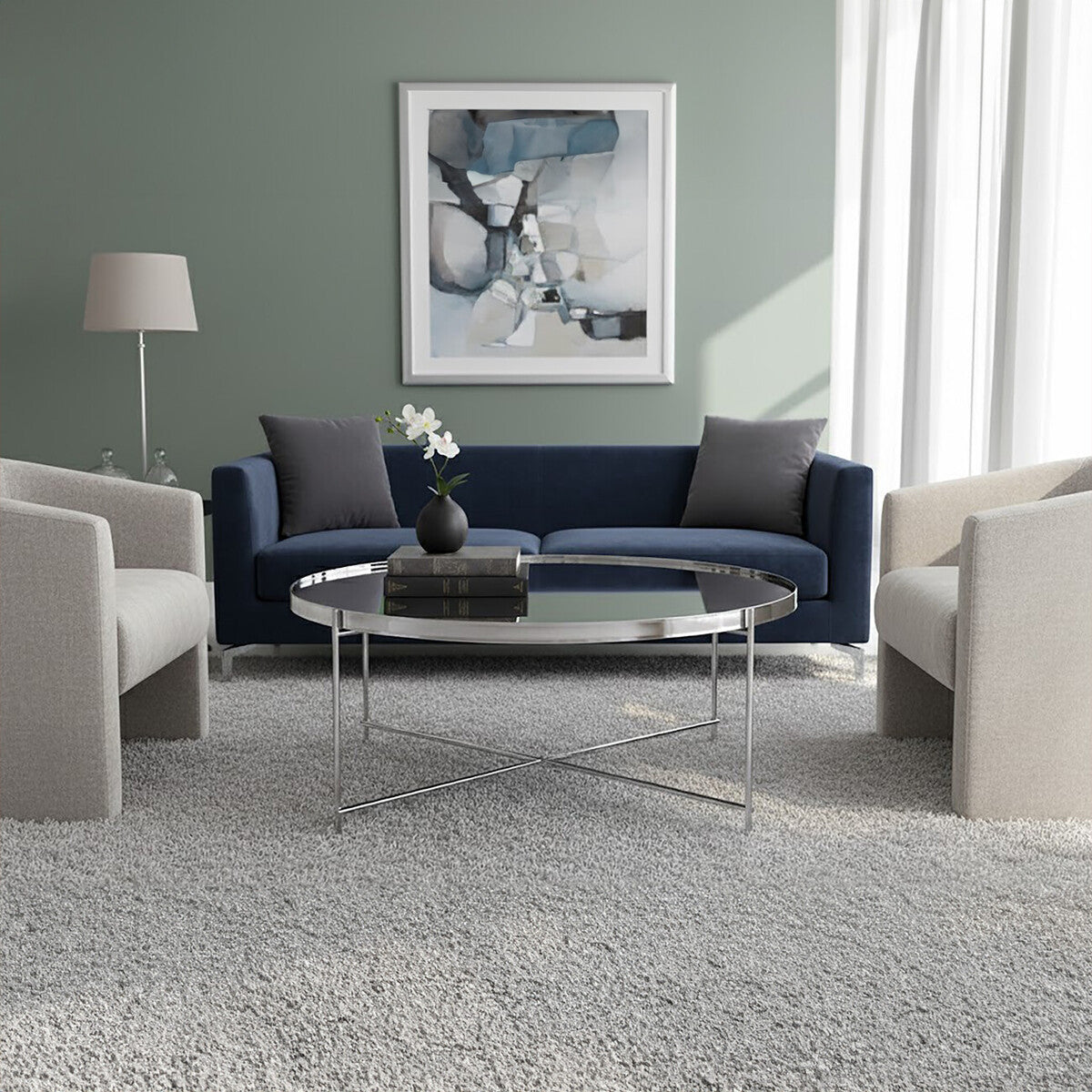 Modern living room with a blue sofa, gray chairs, and a round glass coffee table.