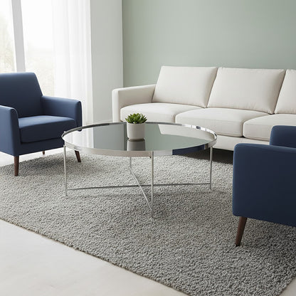 Modern living room with a white sofa, blue armchair, and glass coffee table.
