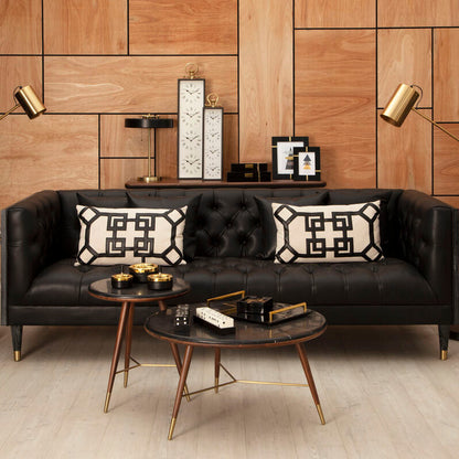 Modern living room with a black sofa, decorative pillows, and a wooden coffee table.