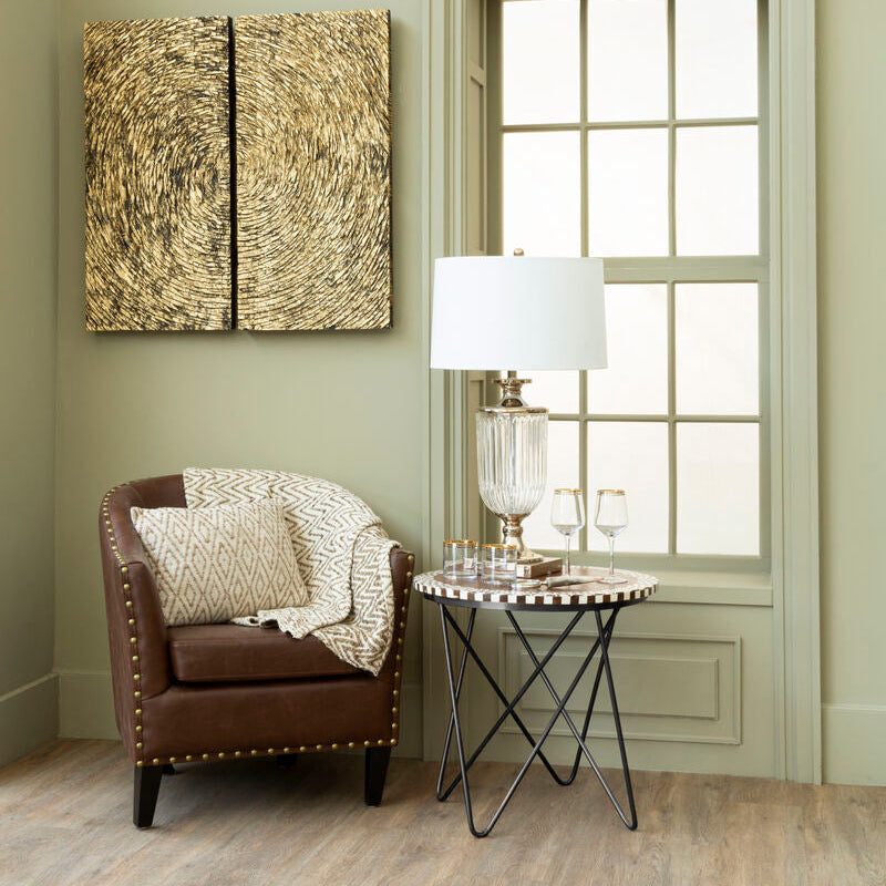 Living room with brown armchair, round table, and abstract wall art.