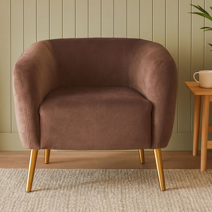 Brown armchair with gold legs in a room with a wooden floor and green wall.