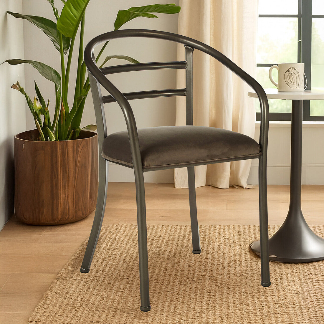 Gray chair in a room with a plant and small table