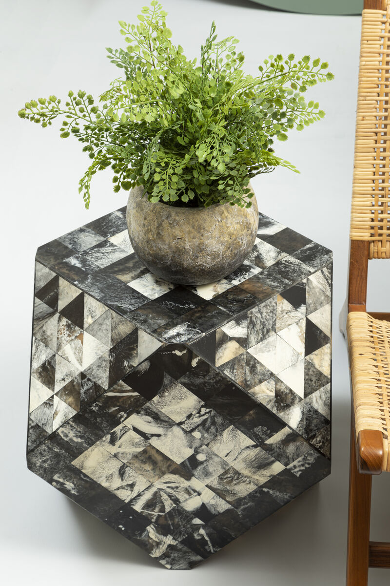 Hexagonal marble side table with a potted plant on a white surface