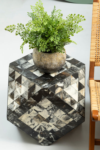 Hexagonal marble side table with a potted plant on a white surface