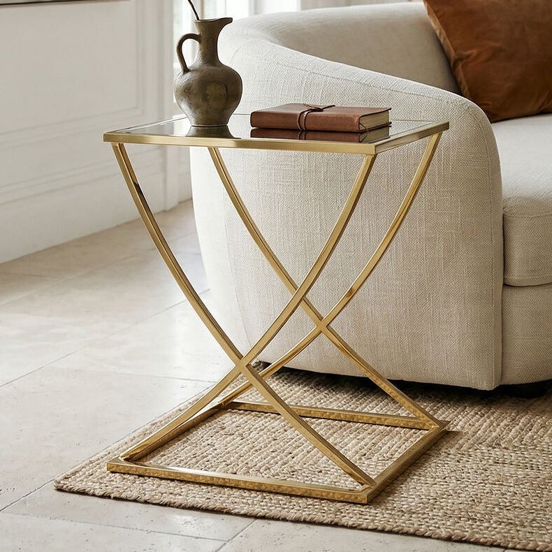 Modern living room with a white sofa, gold side table, and decorative items.