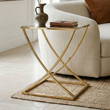 Modern living room with a white sofa, gold side table, and decorative items.