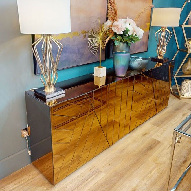 Modern interior design with a metallic console table, lamps, and decorative items.