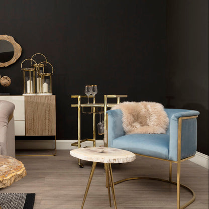 Modern living room with gray sofa, blue armchair, and decorative table against a dark wall.