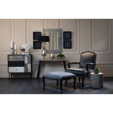 Modern interior design with a console table, mirror, and chairs in a room with wooden paneling.