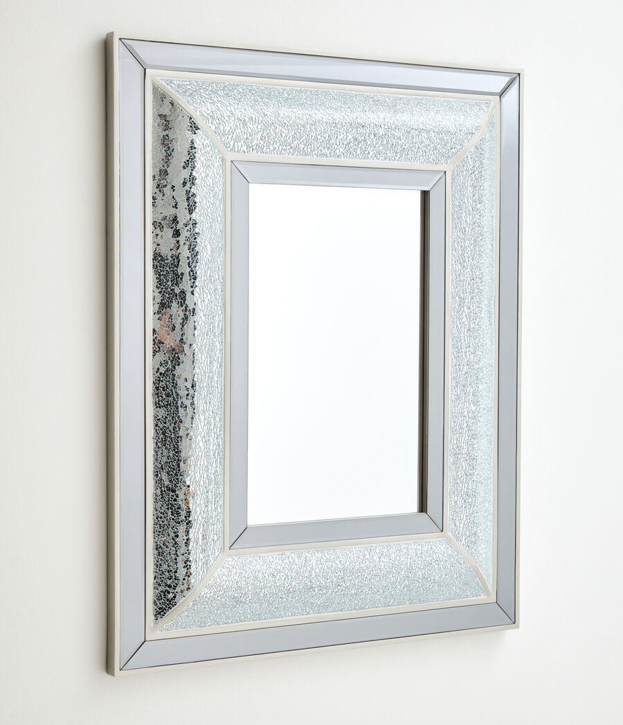 Silver framed mirror with textured border on a white wall