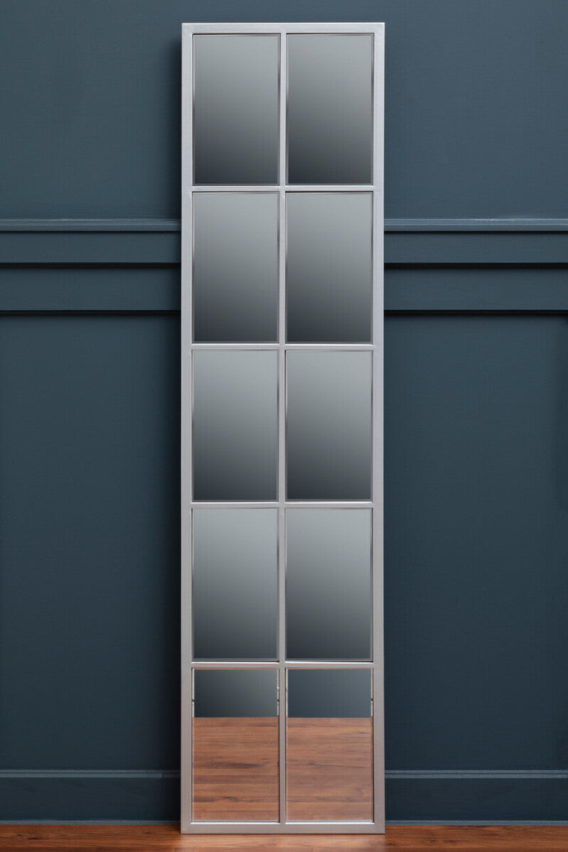 Tall vertical mirror with grid design against a dark blue wall.
