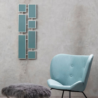 Light blue chair with a gray ottoman and decorative wall art in a room with gray walls.