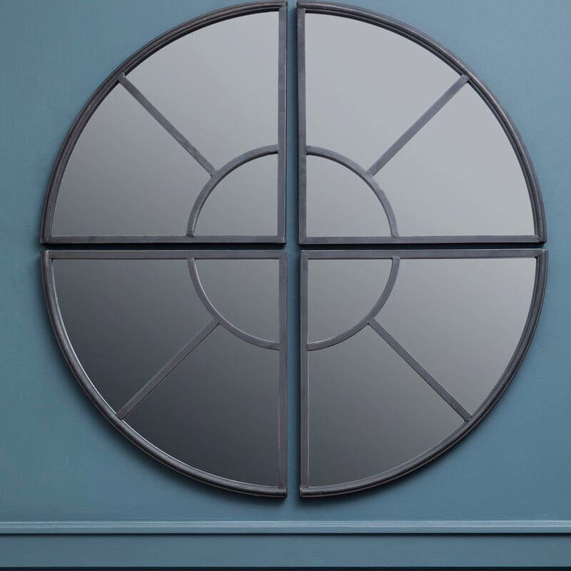 Decorative circular mirror with geometric design on a blue wall