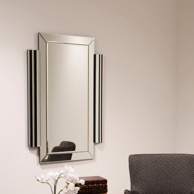 Modern interior with a dark armchair, geometric side table, and decorative mirror.