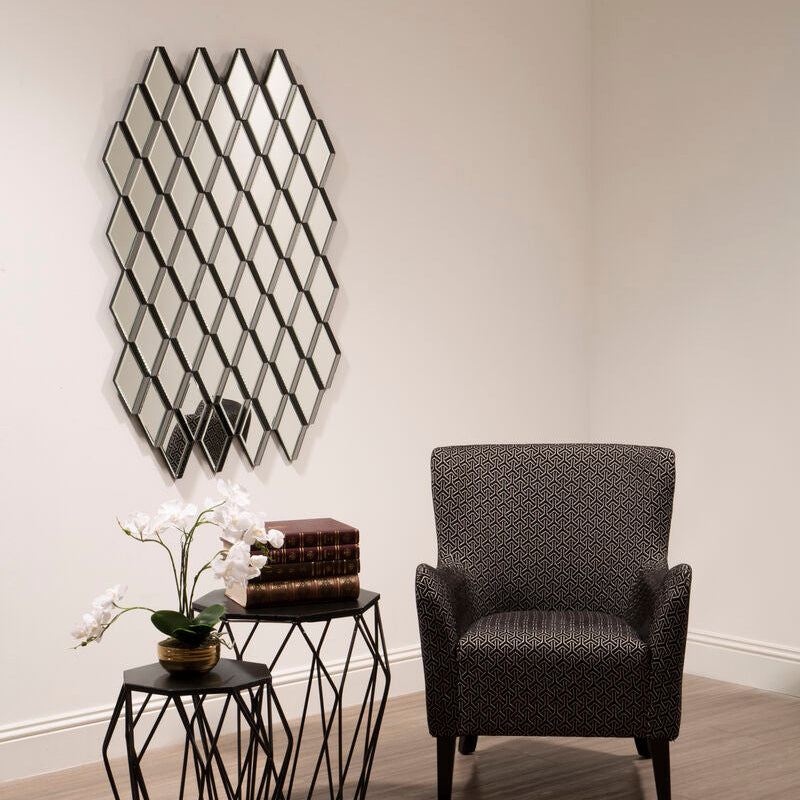 Modern interior with a textured armchair, decorative table, and wall mirror.