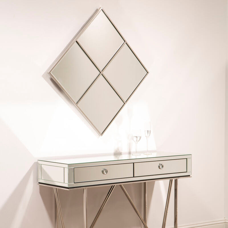 Console table with two drawers and a decorative mirror on a white wall.