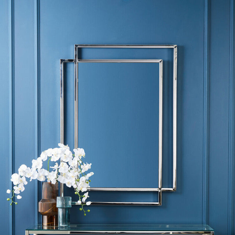 Modern console table with decorative items against a blue wall